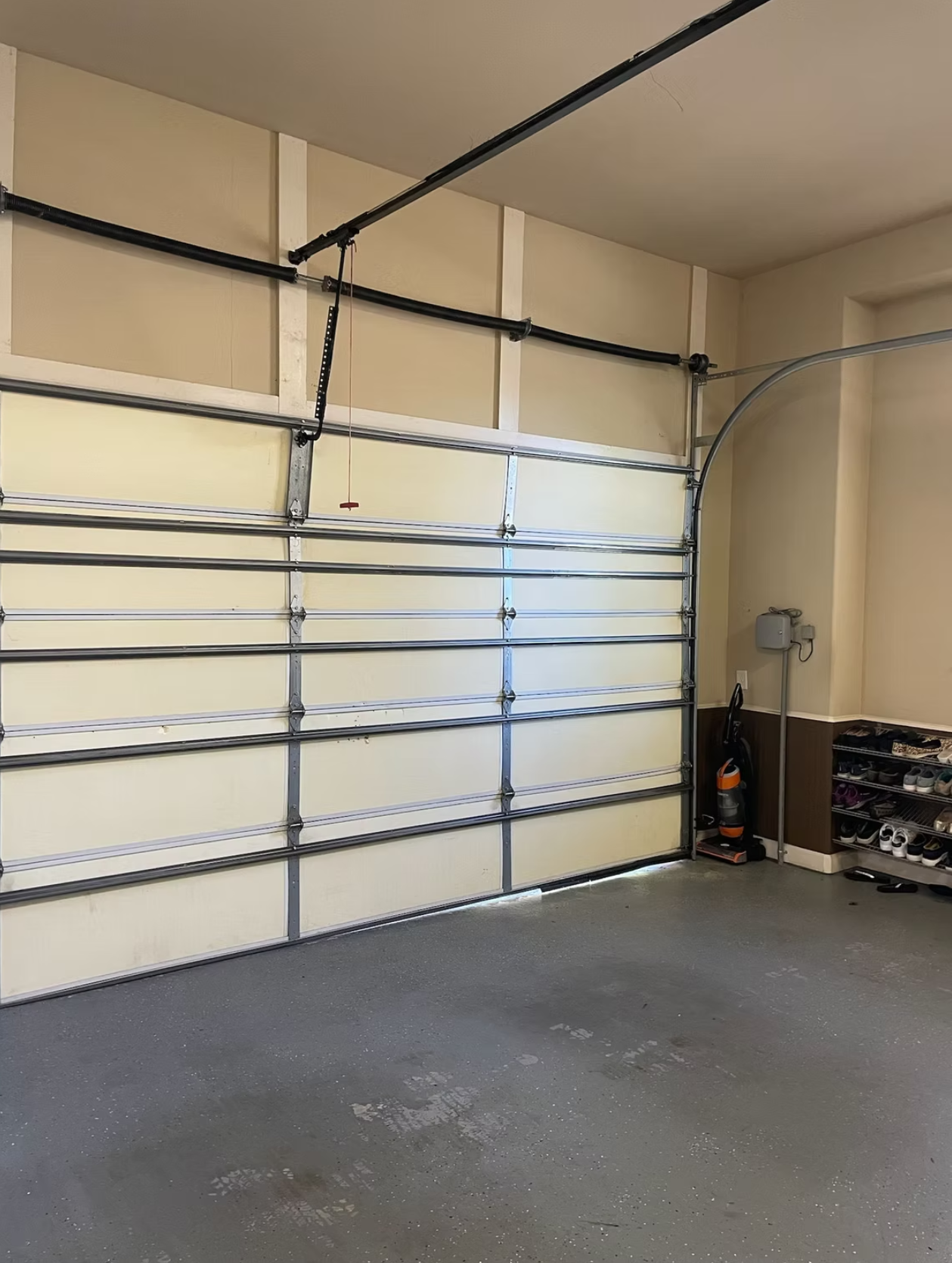 Open garage interior with glass door and metal tracks overhead.