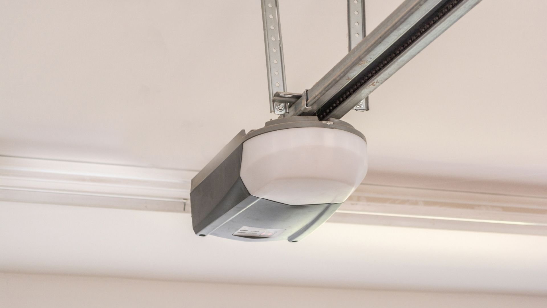 Modern garage door opener motor mounted on ceiling with metal track system